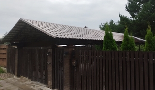 Двускатный навес из коричневой металлочерепицы для дома